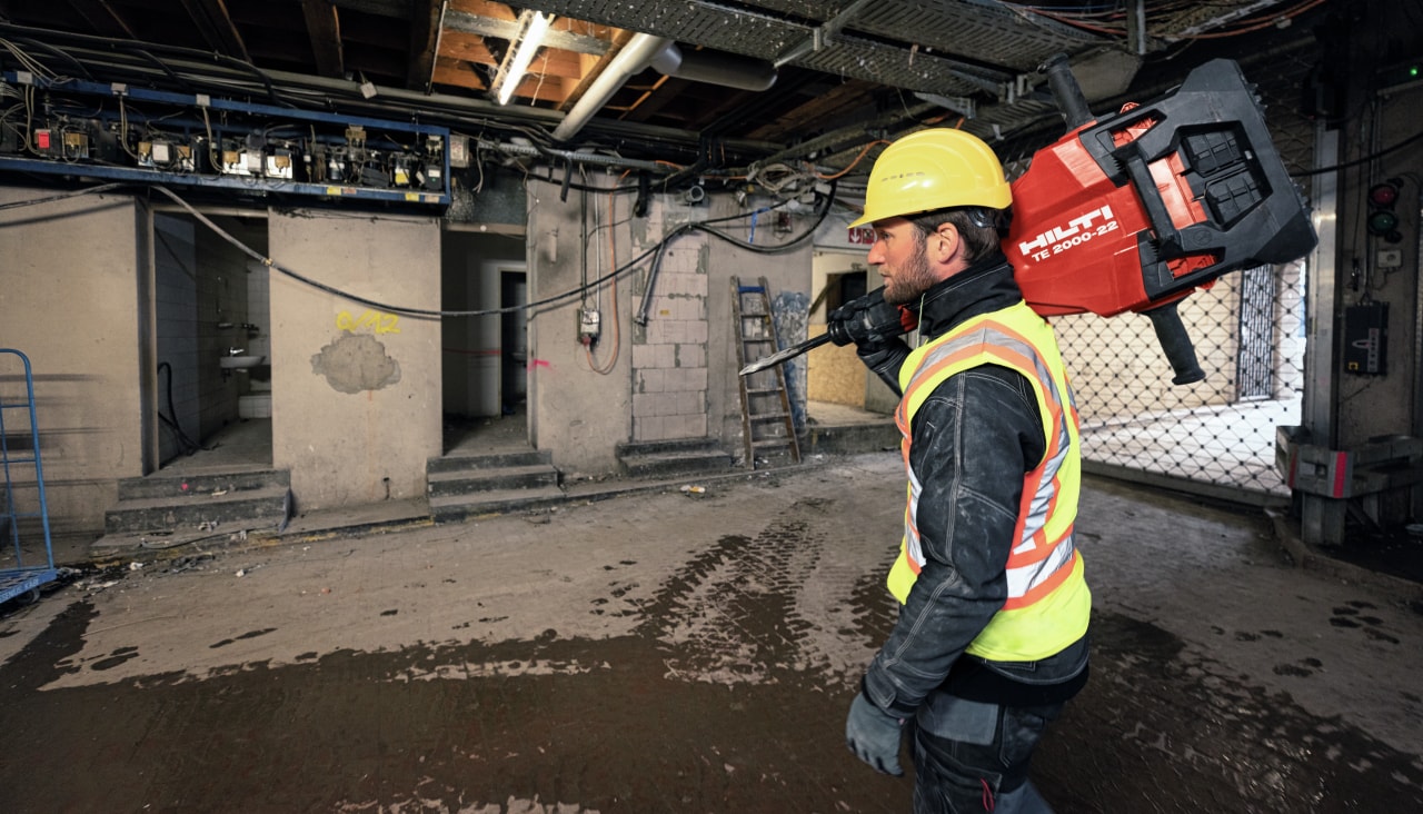 Travailleur transportant le marteau-piqueur sans fil TE 2000-22 sur un chantier