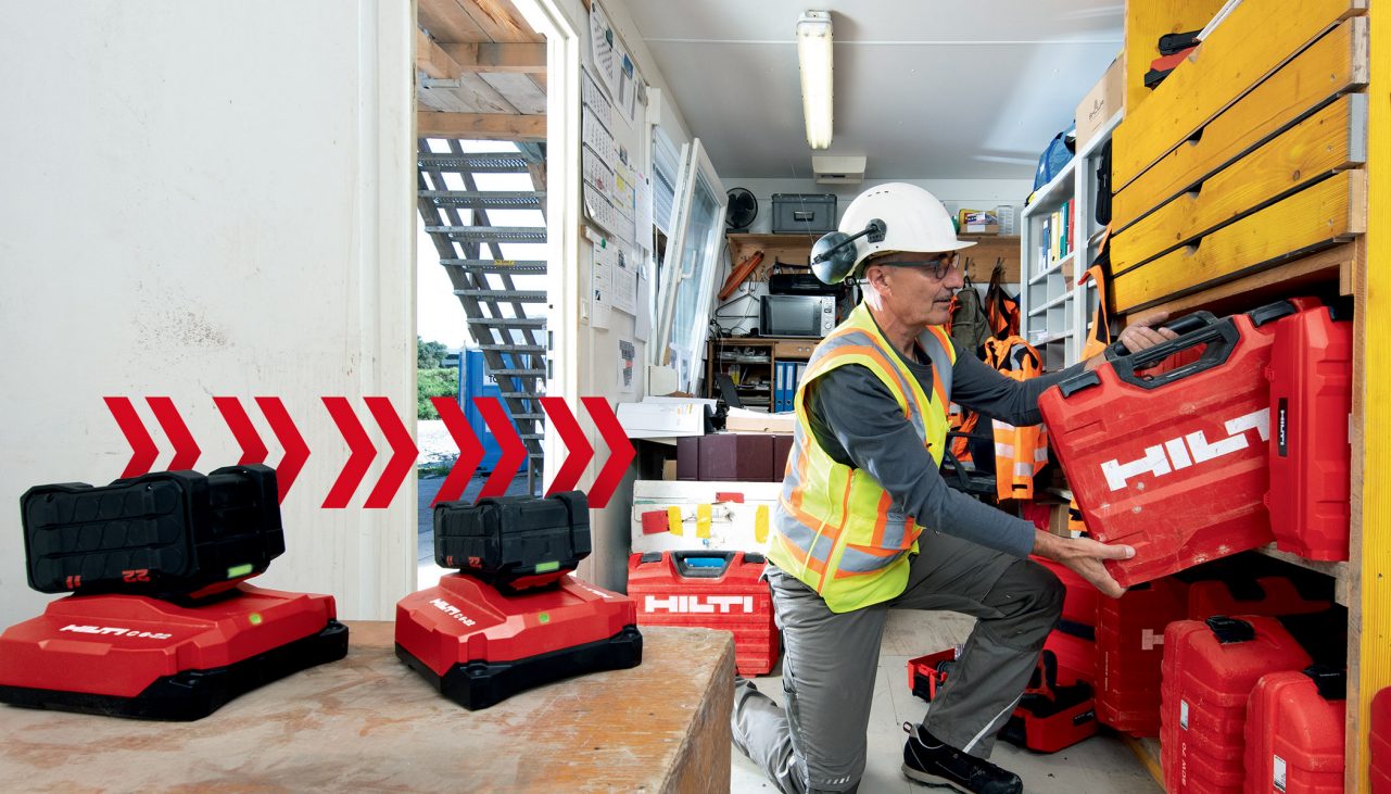 Responsable du parc d'outils rangeant une boîte à outils Hilti sur une étagère dans un conteneur de construction